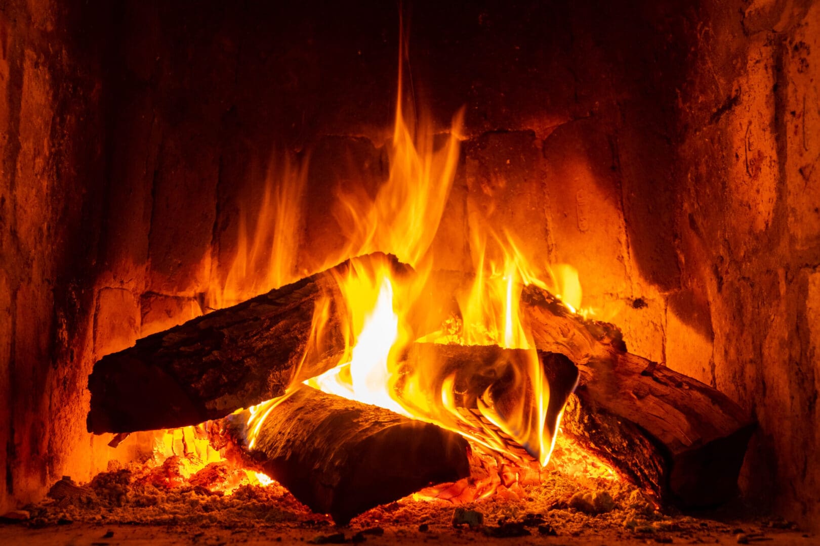 Fire in a fireplace with logs and flames creating a sense of warmth and coziness. Keep warm.